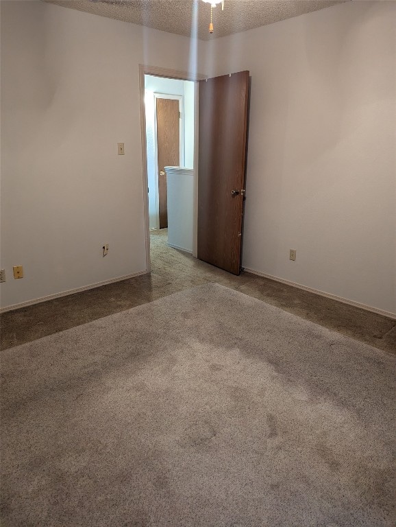 carpeted spare room featuring a textured ceiling