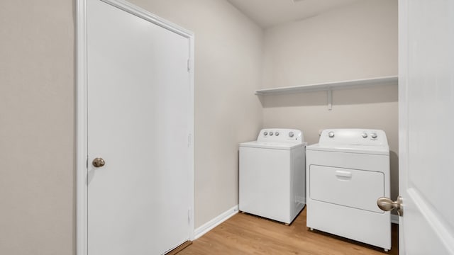 laundry room with washer and dryer and light hardwood / wood-style floors