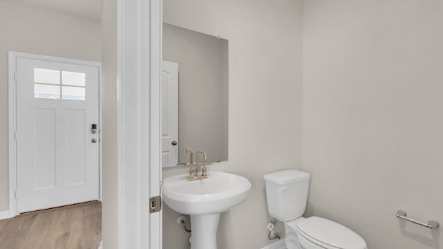 bathroom with toilet and hardwood / wood-style flooring