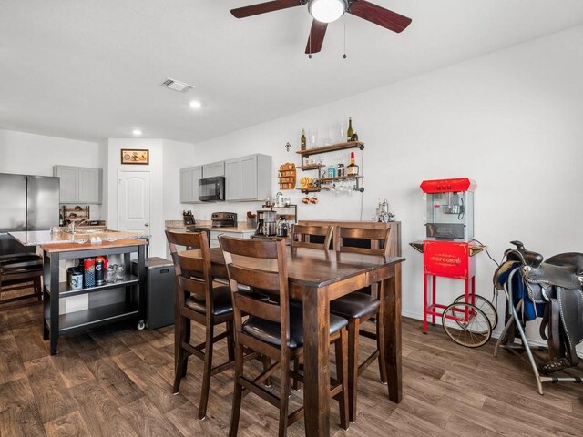 dining area with dark wood-type flooring and ceiling fan