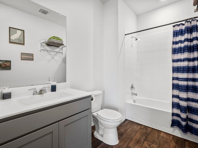 bathroom with toilet, wood finished floors, visible vents, vanity, and shower / bathtub combination with curtain