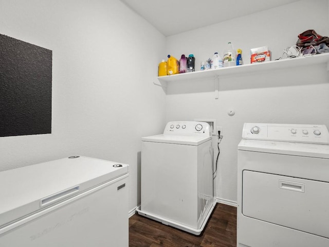 clothes washing area with dark wood-style floors, laundry area, and separate washer and dryer