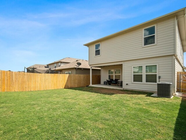 back of house with a patio area, a yard, and central AC