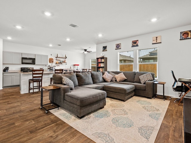 living room with ceiling fan, visible vents, wood finished floors, and recessed lighting