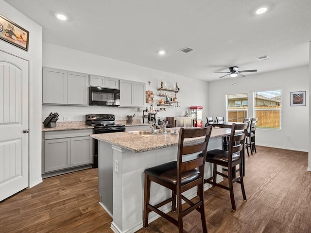 19104 Romano Dr, Elgin, TX 78621 - kitchen with black appliances, gray cabinetry, a sink, dark wood-type flooring, and recessed lighting