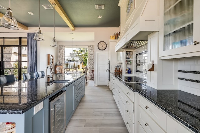 kitchen featuring wine cooler, sink, decorative light fixtures, and beam ceiling