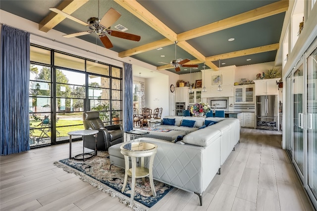 living room featuring beam ceiling, light hardwood / wood-style flooring, and ceiling fan