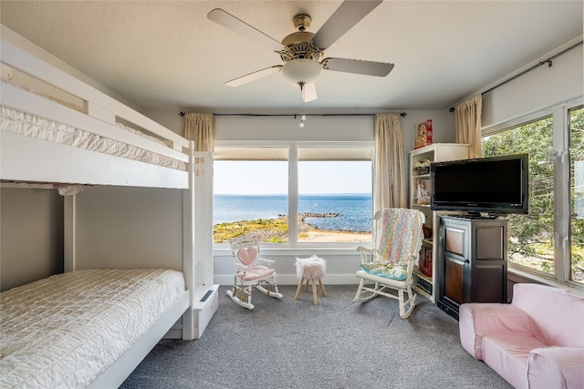 bedroom featuring ceiling fan, multiple windows, and carpet floors