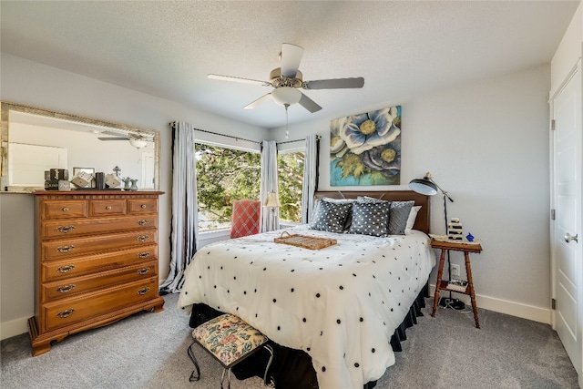 carpeted bedroom with ceiling fan and a textured ceiling