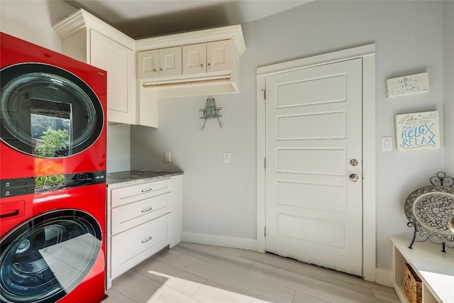 mudroom featuring stacked washer / dryer and light tile patterned floors