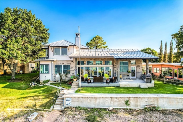 rear view of property with a lawn, outdoor lounge area, and a patio area