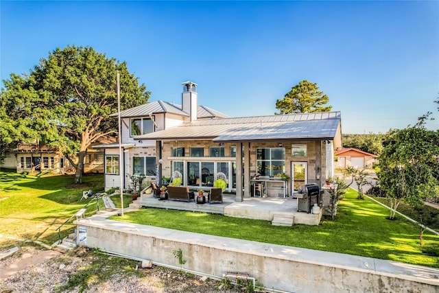 rear view of house featuring a patio area and a lawn