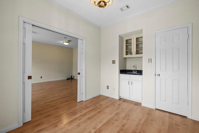 interior space featuring white cabinetry, sink, and light hardwood / wood-style floors