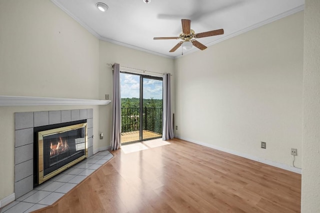 unfurnished living room featuring crown molding, ceiling fan, a fireplace, and light hardwood / wood-style flooring