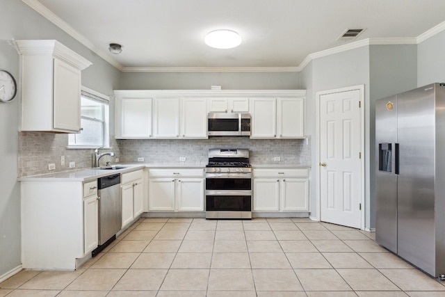 kitchen featuring tasteful backsplash, appliances with stainless steel finishes, and white cabinetry