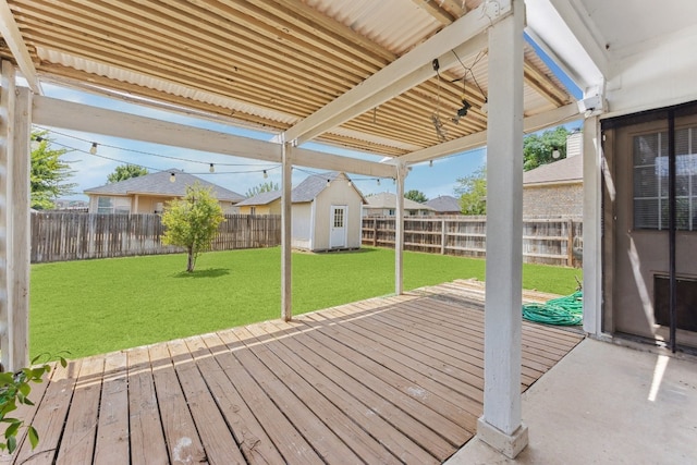 wooden deck featuring a yard and a storage unit