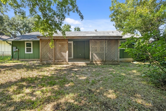 rear view of property featuring a lawn