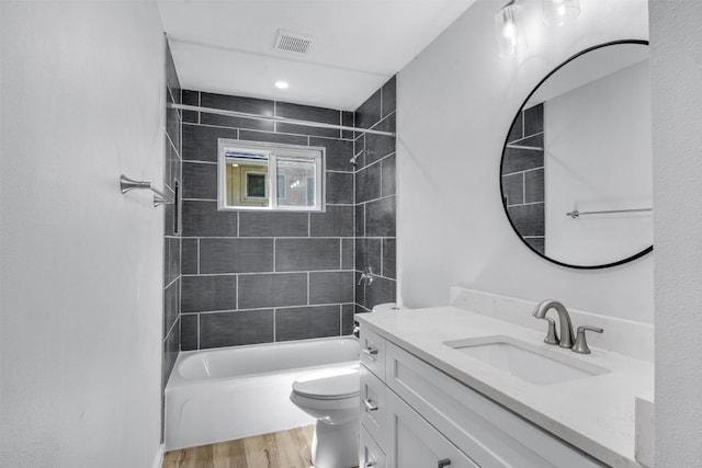 full bathroom with toilet, vanity, tiled shower / bath, and wood-type flooring