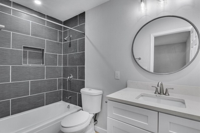 full bathroom with vanity, tiled shower / bath combo, and toilet