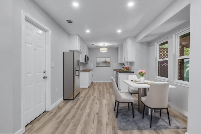 dining room featuring white cabinetry and light wood-type flooring