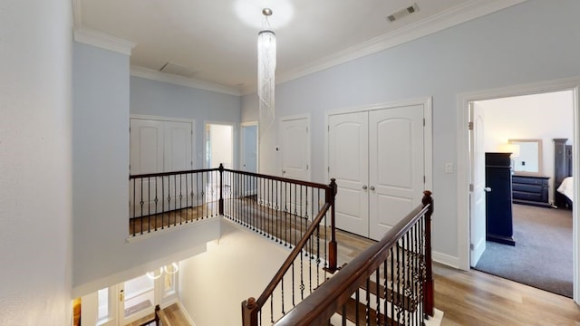 corridor featuring ornamental molding and light hardwood / wood-style flooring