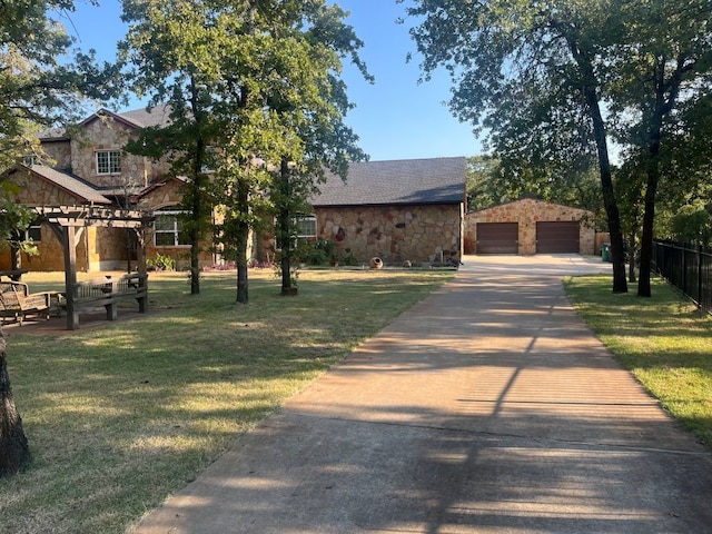 view of front of house featuring an outbuilding, a garage, and a front yard