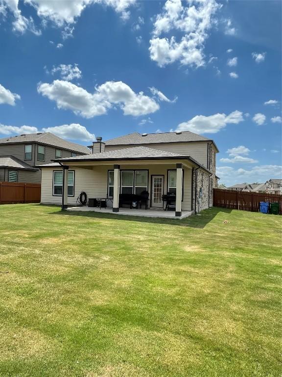 back of house featuring a patio and a yard