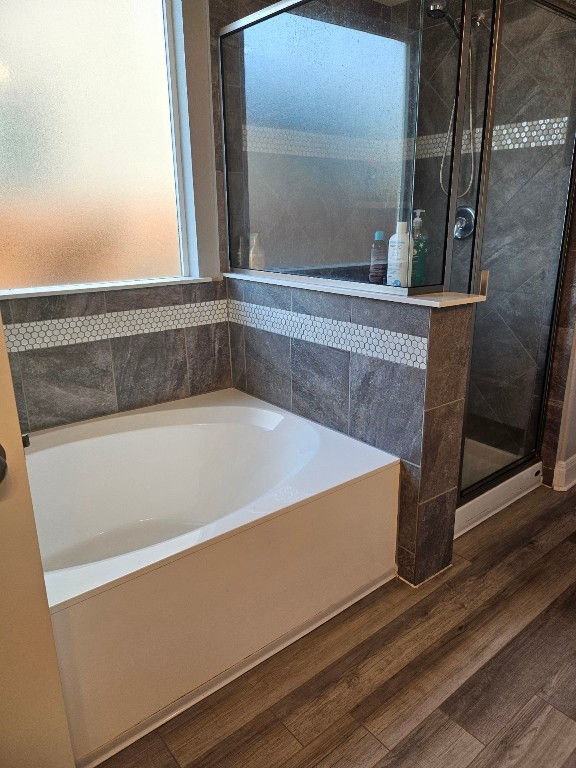 bathroom featuring separate shower and tub and wood-type flooring