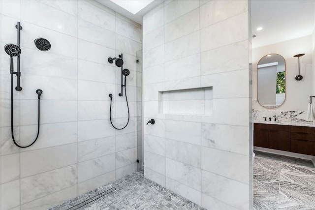 bathroom with vanity and tiled shower