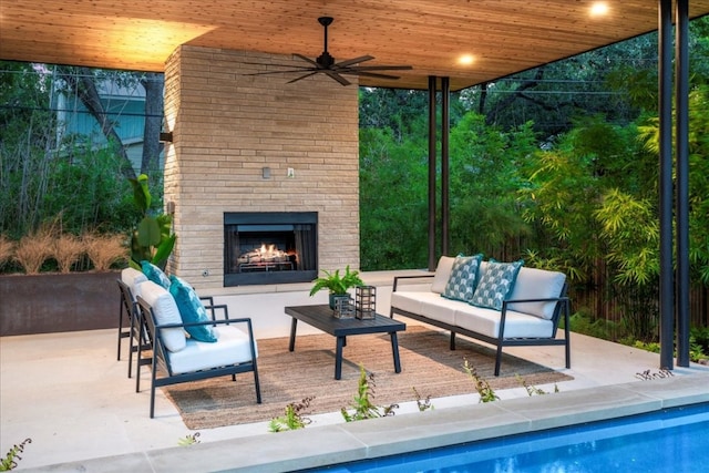 view of patio with an outdoor living space with a fireplace and ceiling fan