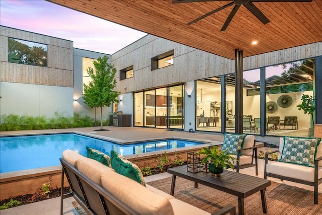 pool at dusk featuring an outdoor living space, a patio, and ceiling fan