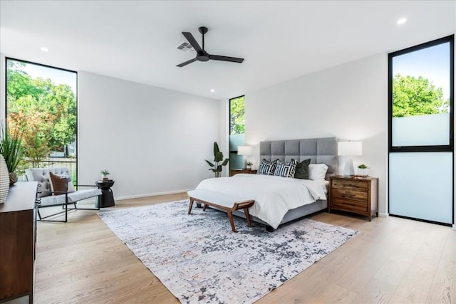 bedroom featuring expansive windows, light wood-style floors, visible vents, and recessed lighting
