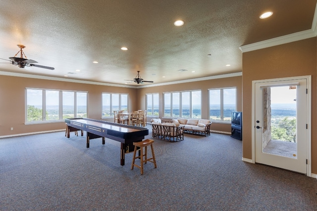 game room featuring a textured ceiling, ornamental molding, ceiling fan, and carpet floors