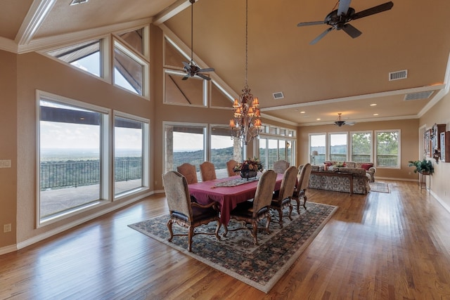 dining area with crown molding, hardwood / wood-style flooring, and ceiling fan with notable chandelier