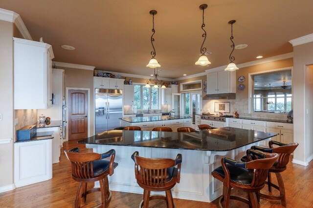 kitchen featuring stainless steel built in fridge, backsplash, and a center island