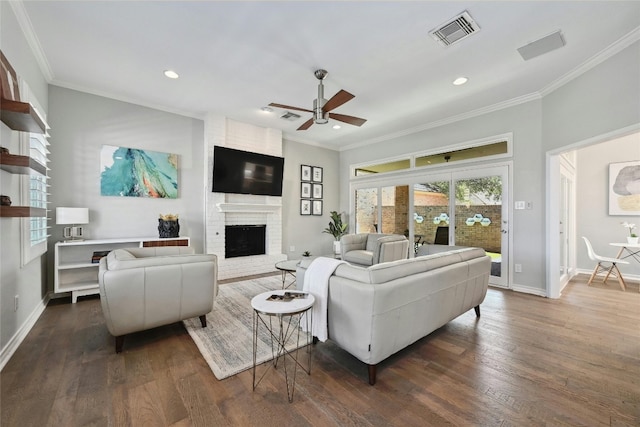 living room featuring a fireplace, ornamental molding, dark hardwood / wood-style flooring, and ceiling fan