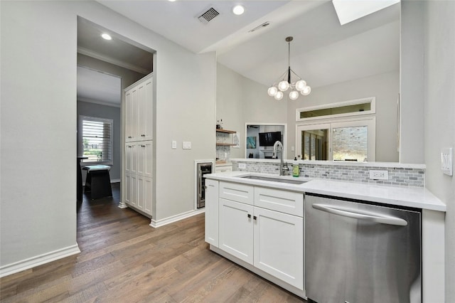 kitchen with white cabinets, dishwasher, sink, and hardwood / wood-style flooring