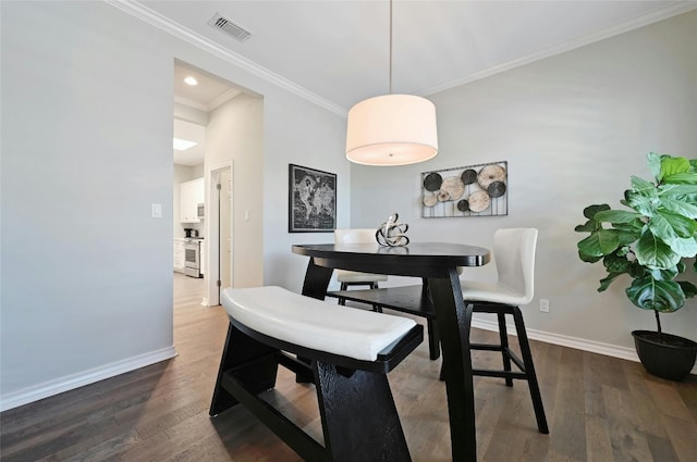 dining space featuring crown molding and dark wood-type flooring