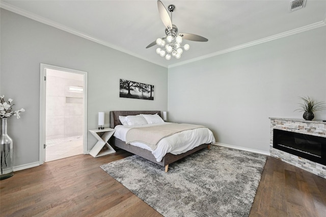 bedroom featuring crown molding, dark hardwood / wood-style flooring, ceiling fan, and ensuite bathroom