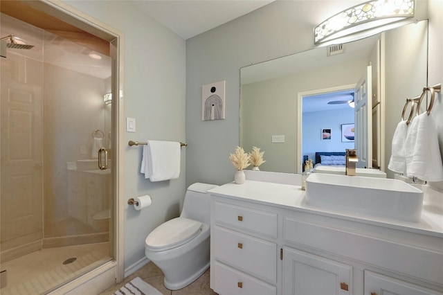 bathroom featuring vanity, walk in shower, tile patterned flooring, ceiling fan, and toilet