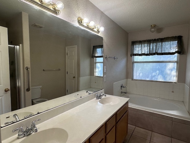 full bathroom featuring a textured ceiling, vanity, toilet, and a wealth of natural light