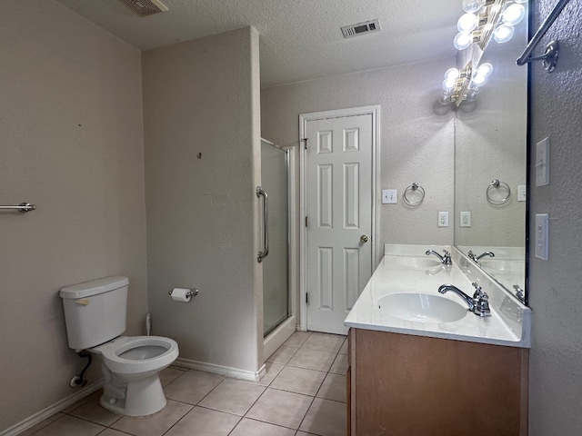 bathroom with tile patterned flooring, a textured ceiling, walk in shower, vanity, and toilet