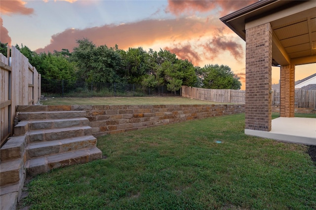 yard at dusk featuring a patio