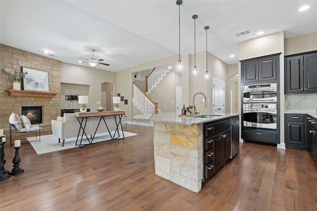 kitchen with sink, a fireplace, and dark wood-type flooring