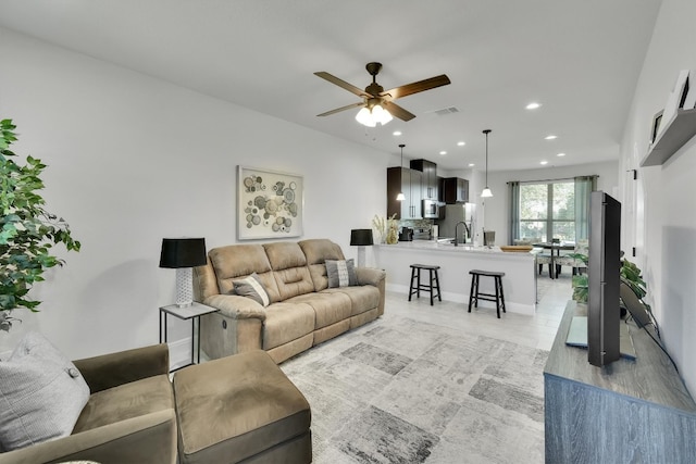 living room with sink, ceiling fan, and light tile patterned floors