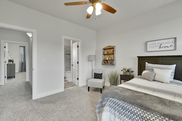 bedroom featuring ceiling fan, light colored carpet, and ensuite bath