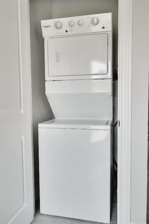 washroom with stacked washing maching and dryer and laundry area