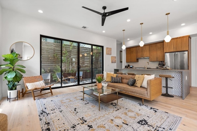 living room featuring light wood-type flooring and ceiling fan