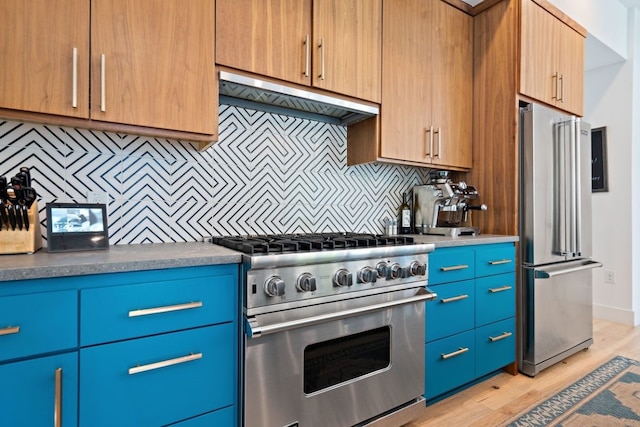 2118 Glendale Pl Unit 1, Austin, TX 78704 - kitchen with premium appliances, under cabinet range hood, tasteful backsplash, and light wood-style floors