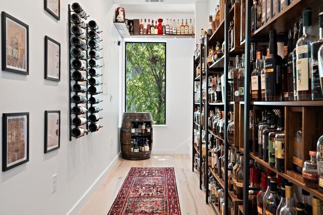 wine cellar with light hardwood / wood-style flooring